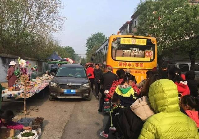 青州這所學(xué)校門(mén)口全是擺攤的，校車(chē)都堵了...