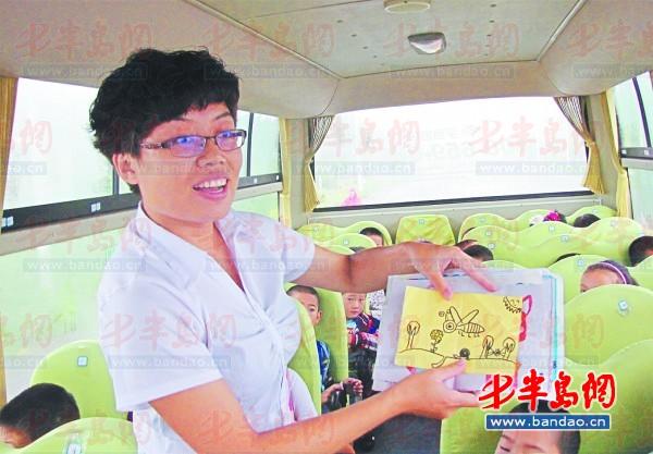 校車隨車照管員劉芳展示她收到的教師節禮物瑯琊臺小學的學生們親手畫的畫。