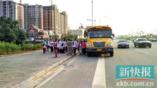 學校旁的鳳凰大道上,家長臨時請來的正規校車正在接送學生。