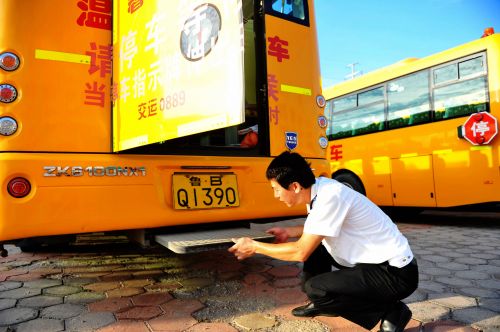 交運(yùn)溫馨校車黃島分公司一名駕駛員在檢查校車逃生門設(shè)置。